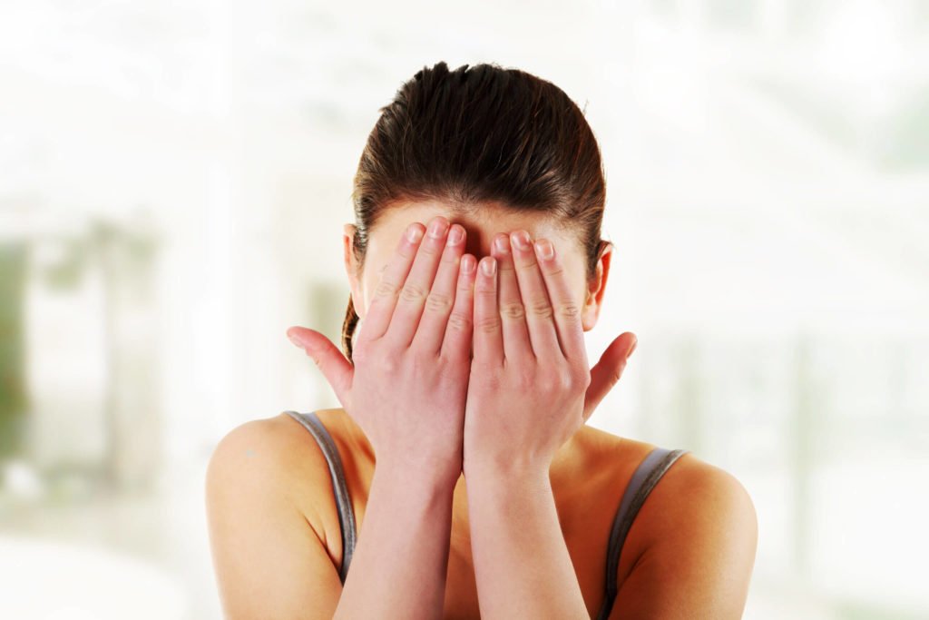 Bühnenpanne, wie peinlich! Eine Frau versteckt ihr Gesicht hinter den Händen vor Scham