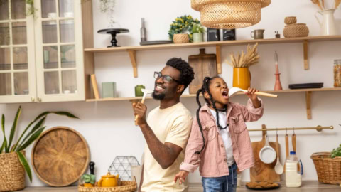 Father and daughter singing in the kitchen, as an example of "Dare and sing"